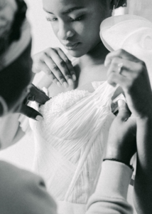 A photograph of Custom Made Wedding Dress Designer Cynthia Grafton-Holt working on her dresses with a bride
